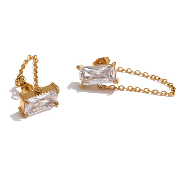 Gold earrings with a rectangular crystal centerpiece and delicate chain accents.