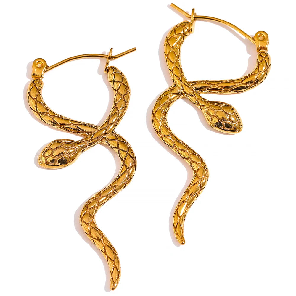 Snake-shaped earrings placed on a sleek surface, highlighting their bold and intricate design