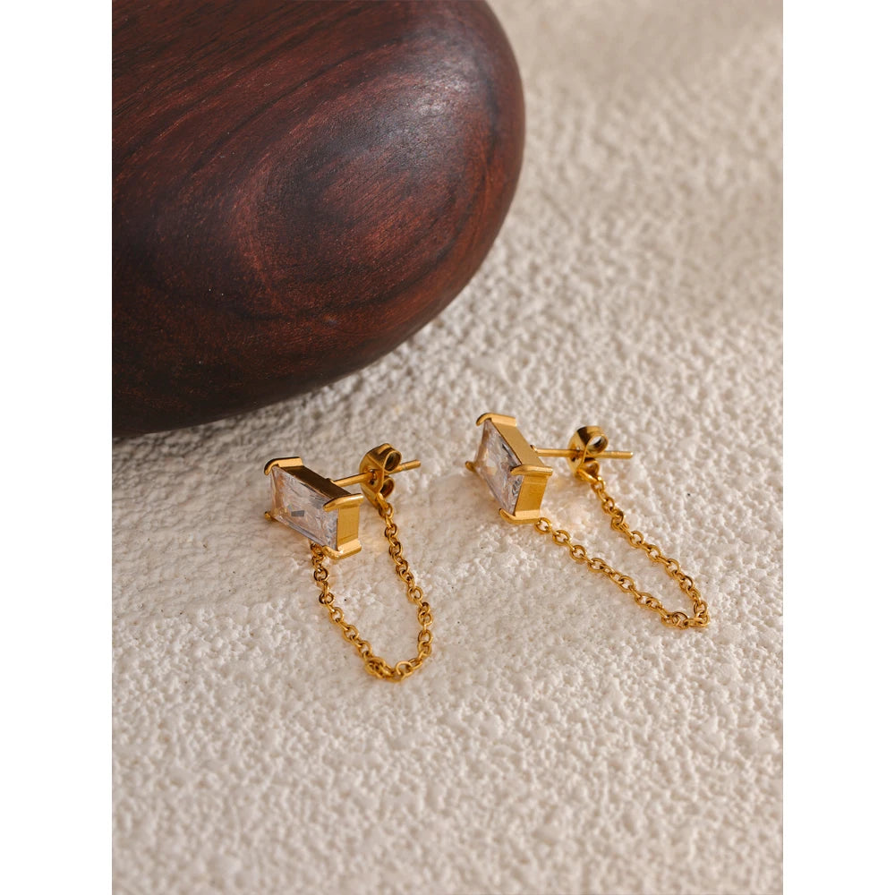 A pair of modern gold earrings featuring sparkling crystals and a chic chain design.